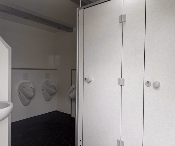 Herrenbereich im Toilettenwagen 6&2 von PZV Elting mit sieben Urinalen, zwei abschließbaren WC-Kabinen und einem Waschbecken.