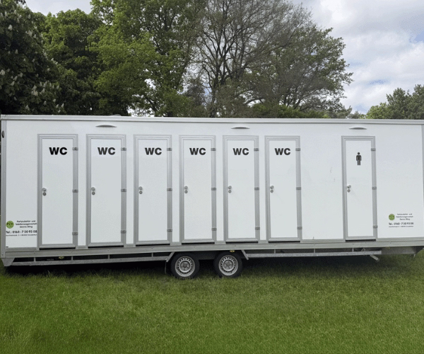 Zweite Außenansicht des Toilettenwagens XXL von PZV Elting mit zwölf Türen, geeignet für Unisex-Nutzung bei Großveranstaltungen, aufgestellt auf einer Wiese.