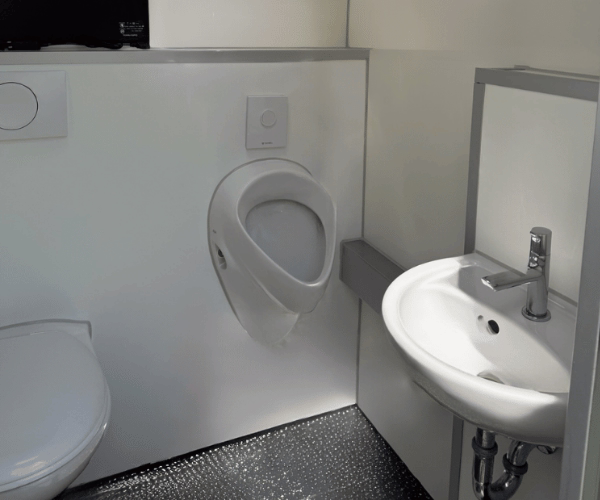 Innenansicht einer mobilen Einzeltoilettenkabine mit Urinal, WC, Waschbecken und Spiegel – PZV Elting Emsdetten.