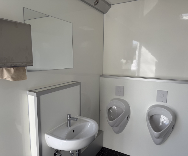 Herrenbereich des Toilettenwagens 4&1 von PZV Elting Emsdetten mit Waschbecken, Spiegel, Handtuchspender und zwei Urinalen