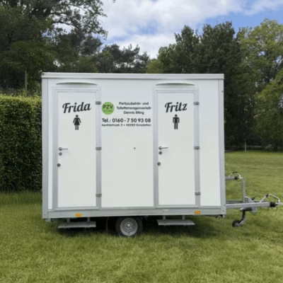 Toilettenwagen 1&1 von PZV Elting mit Frida- und Fritz-Beschriftung auf Wiese